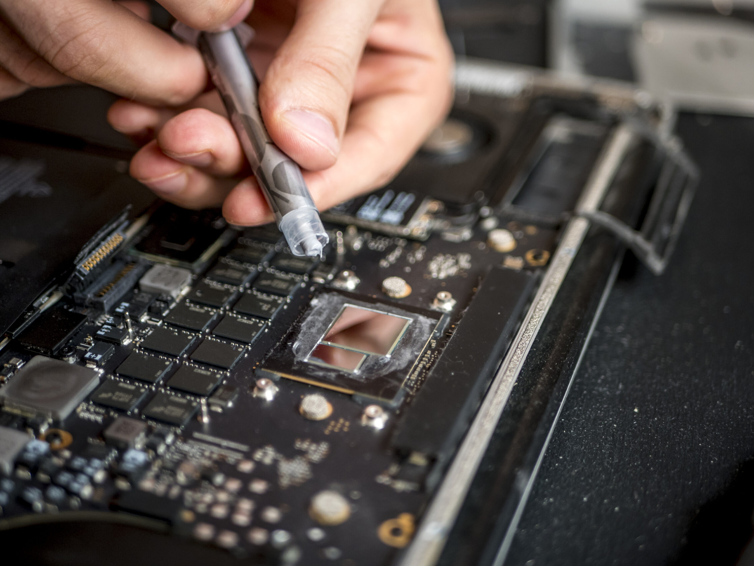 close up hands with thermal paste apply it to laptop cooler system